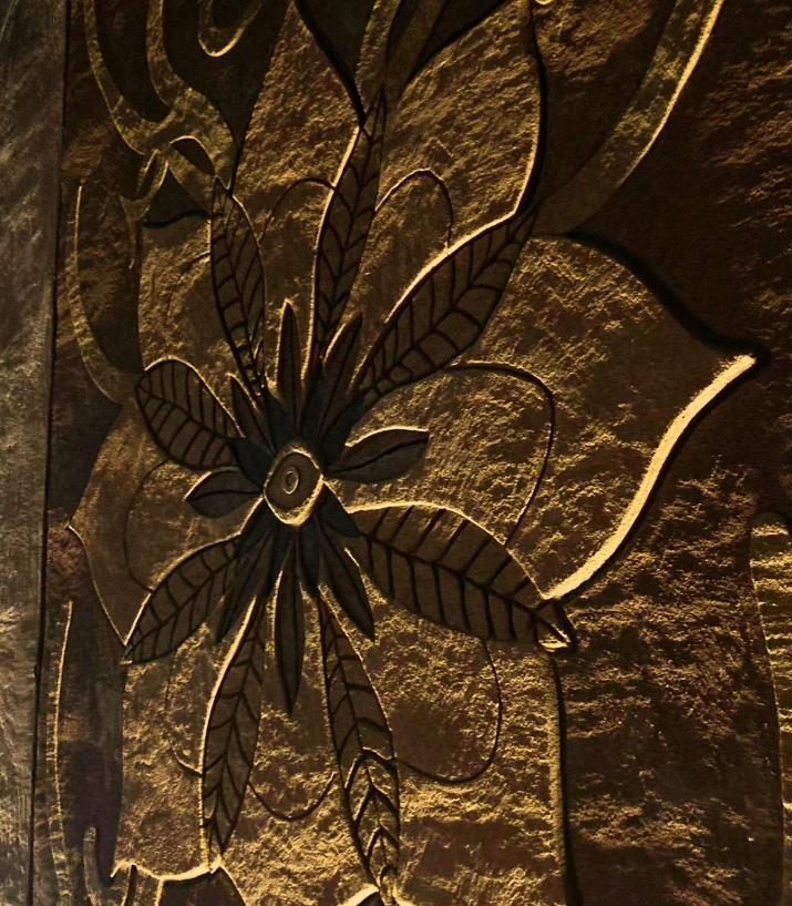 Relieve de una flor esgrafiada bajo luz cálida